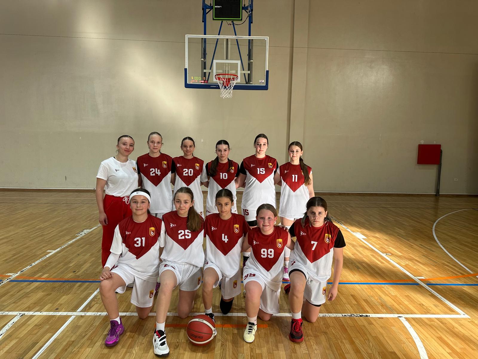 Timska fotografija mladih košarkašica ŽKK Bosna Sarajevo ispod koša u sportskoj dvorani